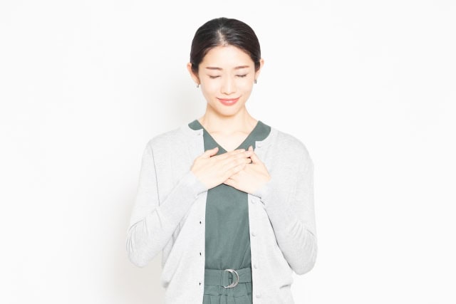 胸に手を当てる女性
