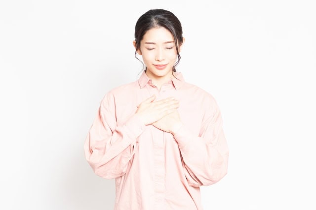 胸に手を当てる女性
