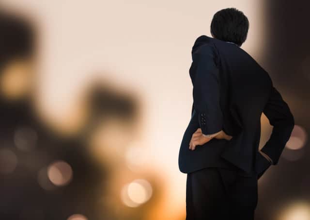 腰に手をあてるビジネスマンのシルエット