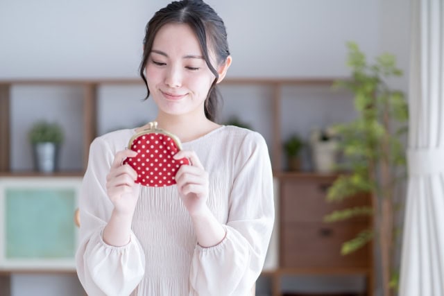 お財布を手に微笑む女性