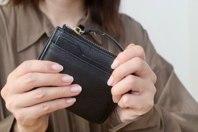 財布を手にもつ女性